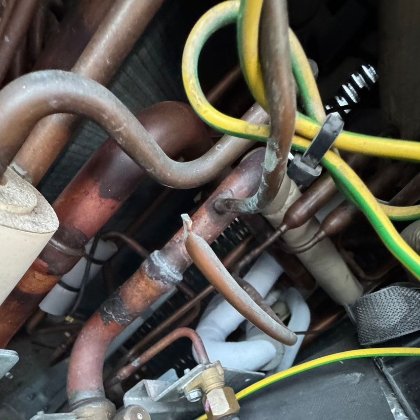 The view of the inside of a HVAC system complete with copper pipes and yellow wires