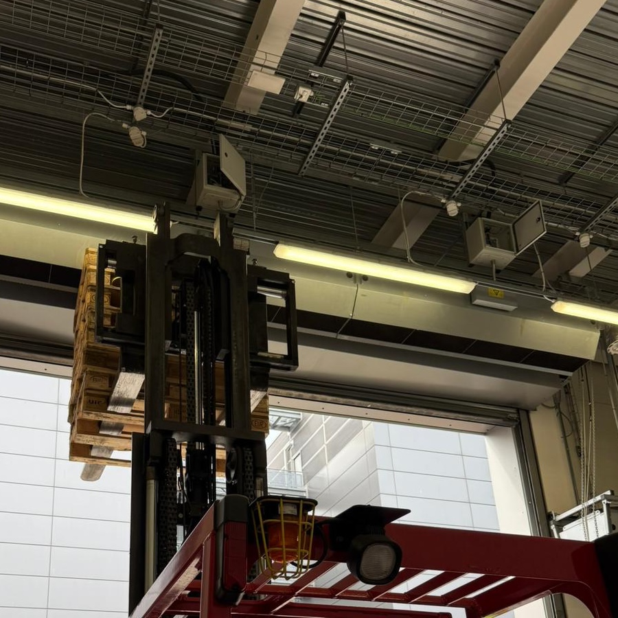 A cherry picker reaching up to a commercial HVAC installation